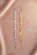 Bracelets chaîne argent et doré à plat sur fond rosé mystique